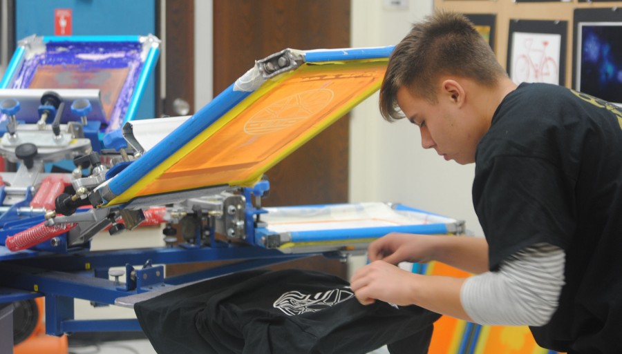 Junior Alex Bielic checks the logo he printed on his shirt during Graphic Arts class.