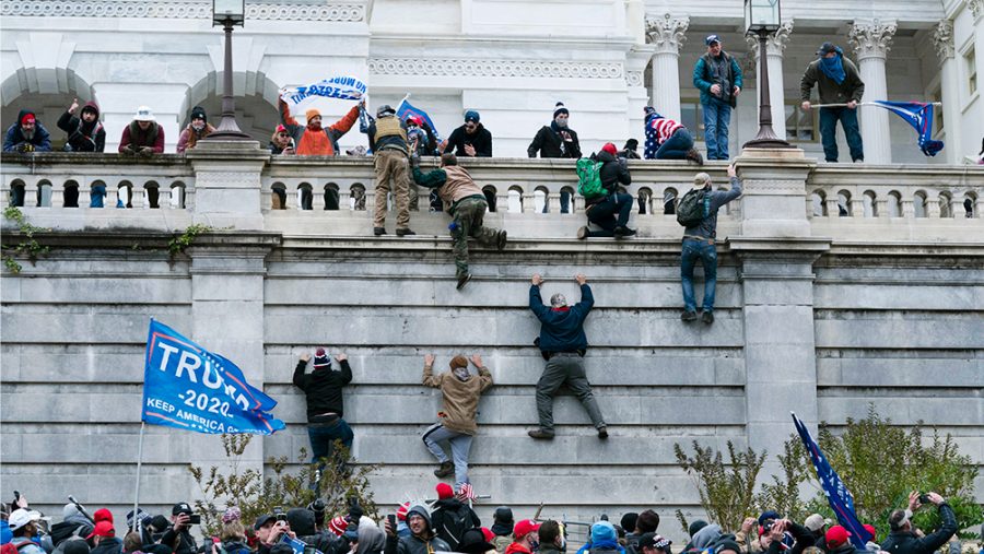 Supporters of President Donald Trump climb the west wall of the the U.S. Capitol on Wednesday, Jan. 6, 2021, in Washington. (AP Photo/Jose Luis Magana)