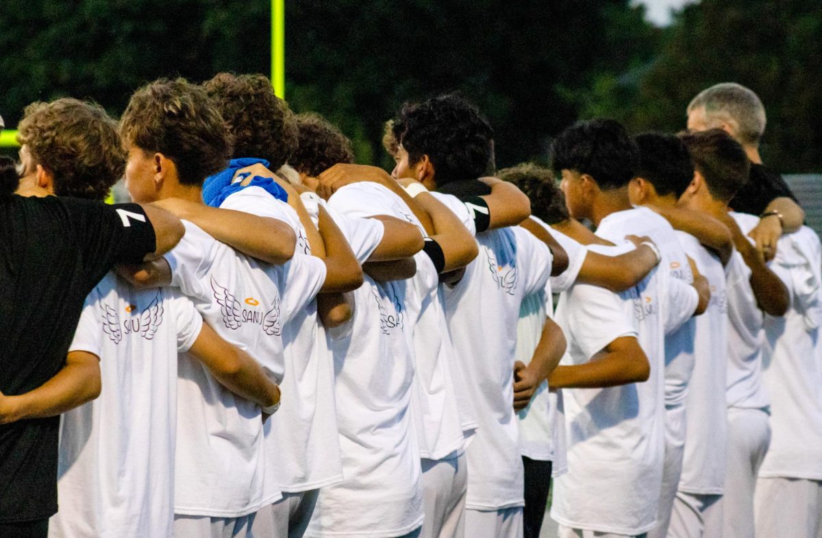 The RMHS soccer team embraces during a match after attending the memorial for teammate Samuel Alfaro 